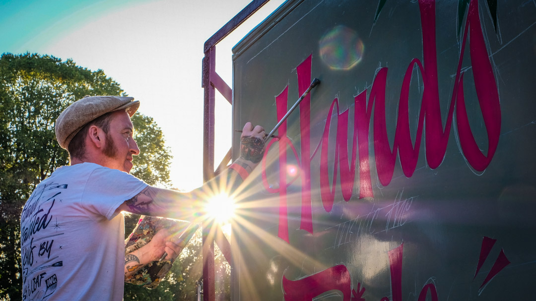 Signwriter using traditional techniques at the Signwriting festival