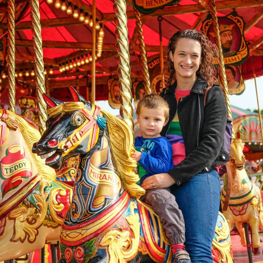 A child winning a soft toy prize at the hook a duck fairground game