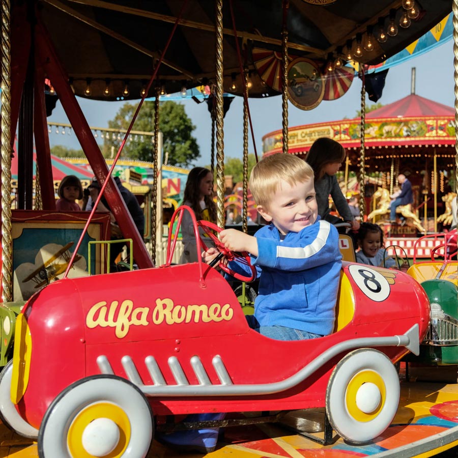 A child winning a soft toy prize at the hook a duck fairground game