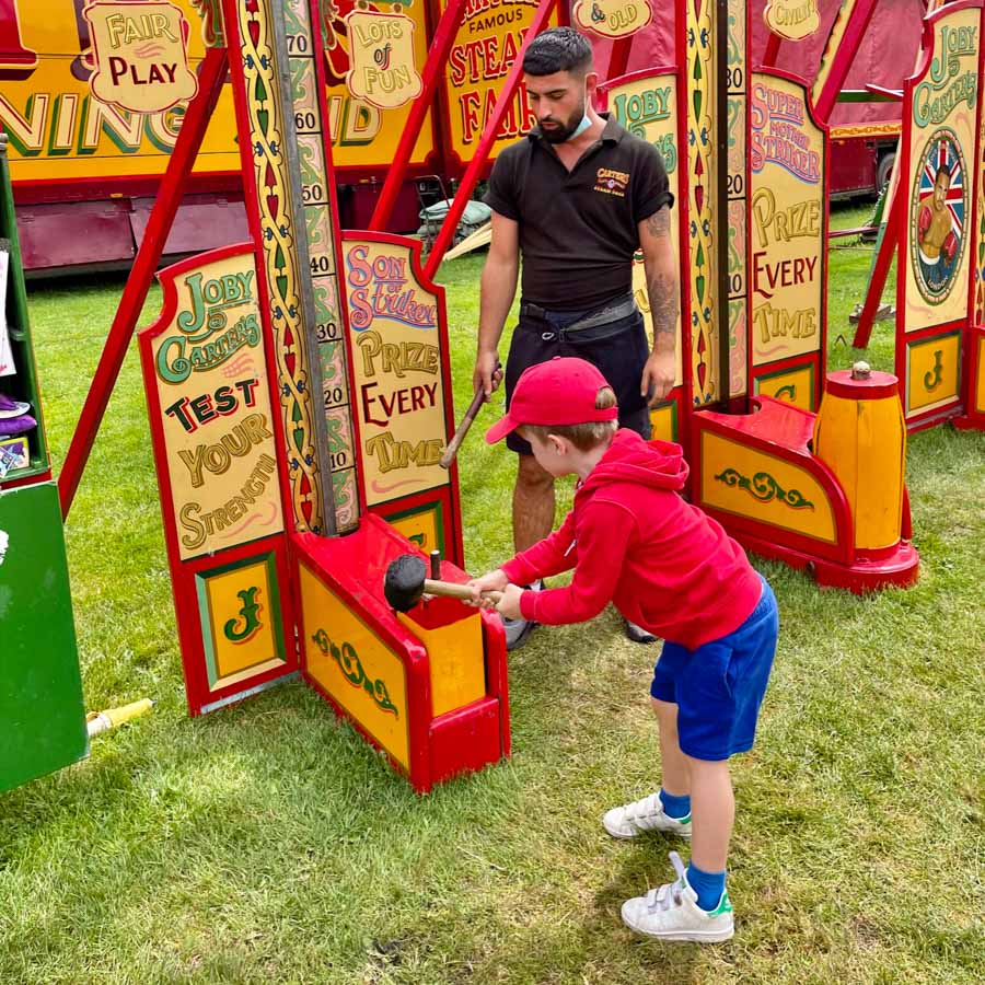 A child winning a soft toy prize at the hook a duck fairground game